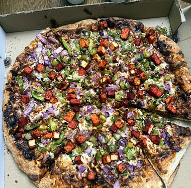 Loaded pizza with green peppers, red onion and spiced toppings